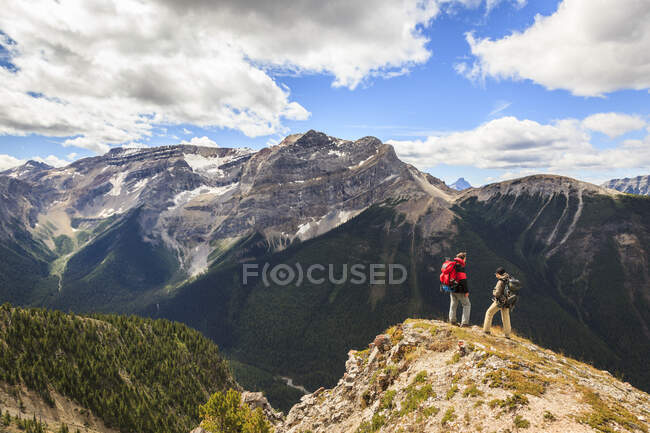 Two back packers hike the Citadel Pass trail from Sunshine Meadows along the Great Divide in Banff National Park, Alberta, Canada. Model Released — Stock Photo