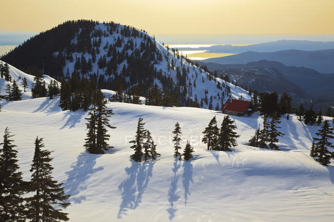 Puesta de sol sobre las montañas cubiertas de nieve del resort Mount Steele Cabin en Columbia Británica Canadá.N - foto de stock