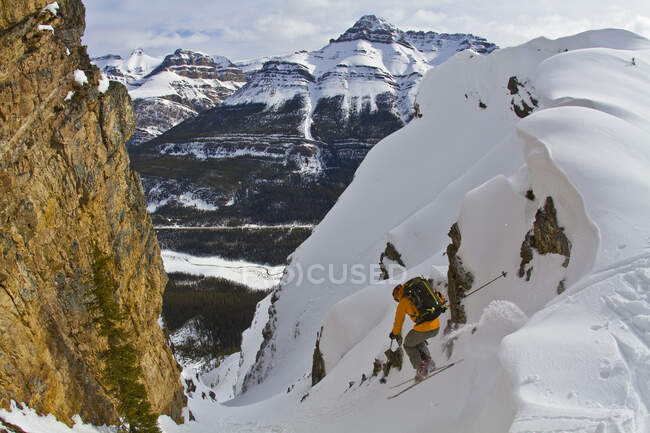 Uno sciatore di backcountry maschile con gli sci da tele cade in un ripido canale lungo il Parco Nazionale di Icefields, Banff, AB — Foto stock