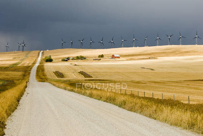 Céu tempestuoso e turbinas na estrada perto de Pincher Creek, Alberta, Canadá — Fotografia de Stock