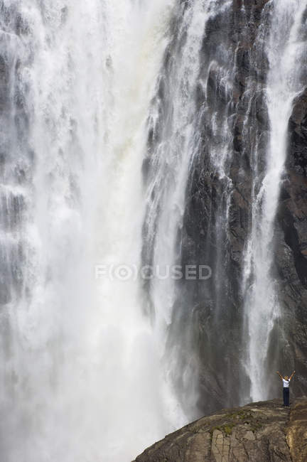 Mujer con los brazos extendidos en Montmorency Falls, Quebec City, Quebec, Canadá . - foto de stock