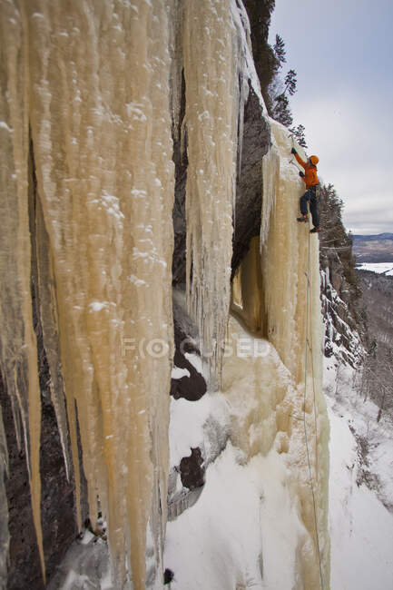 Hombre escalando hielo amarillento cerca de Saint Raymond, Quebec, Canadá - foto de stock