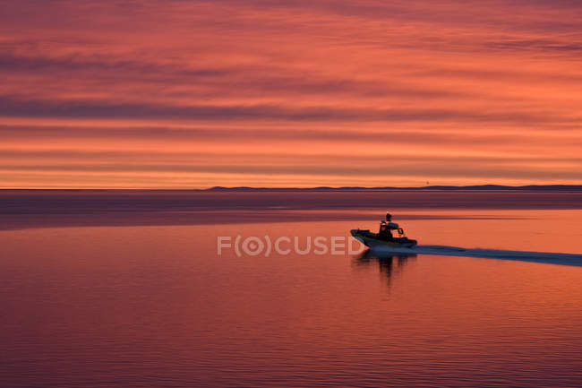 Mann im Boot bei Sonnenuntergang am Fluss Saguenay, baie-sainte-catherine, charlevoix, quebec, canada — Stockfoto