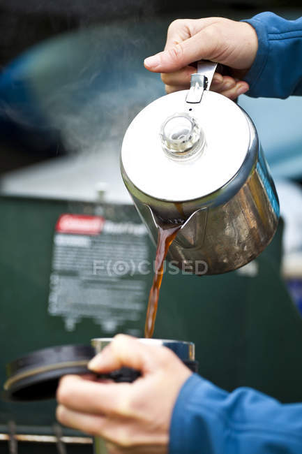 Vista ritagliata della donna versando caffè durante il campeggio . — Foto stock