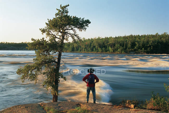 Vue arrière d'un randonneur le long de la rivière Winnipeg aux chutes Sturgeon, parc provincial Whiteshell, Manitoba, Canada . — Photo de stock