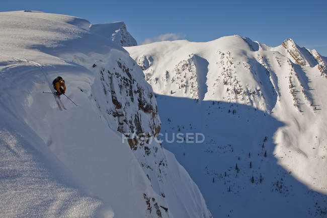 Männlicher Skifahrer, der vom Gesims im Hinterland des Tretroller-Resorts abfällt, golden, britisch columbia, Kanada — Stockfoto