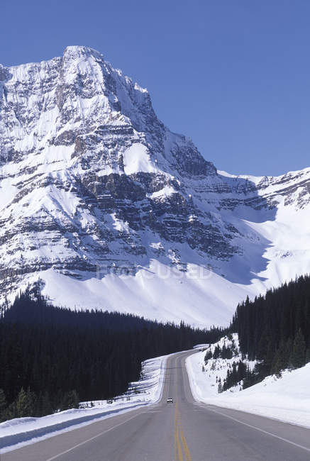 Highway with riding car in spring in Rocky Mountains, Alberta, Canada . — стоковое фото