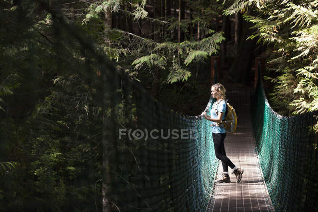 Молодая женщина-туристка на подвесном мосту между Чайна-Бич и Мистик-Бич вдоль Хуан-де-Фука Трейл, остров Ванкувер, Канада . — стоковое фото