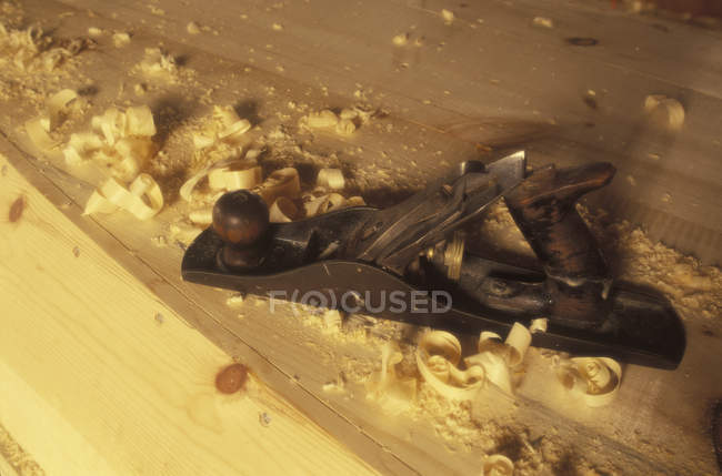 Tool at board for boat building with wood shavings — Stock Photo