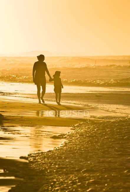 Жінка з дочкою ходьбі взявшись за руки на пляжі на Profitts точки поблизу Darnley, Острів Принца Едуарда, Канада. — стокове фото