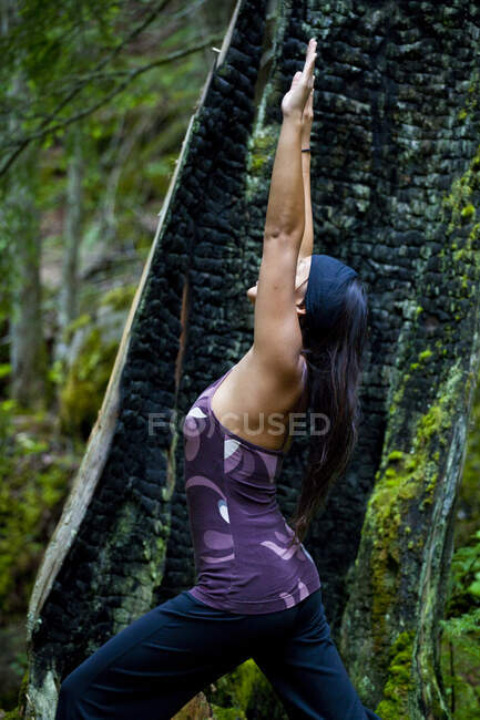Asian woman practicing yoga near Clearwater River, Clearwater, British Columbia, Canada — Stock Photo
