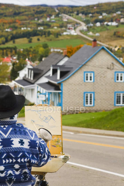 Artista em oficina de pintura desenhando paisagem de aldeia em Charlevoix, Quebec, Canadá — Fotografia de Stock