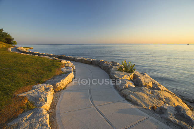 Percorso in pietra lungo la riva del lago Ontario all'alba, Niagara-on-the-Lake, Ontario, Canada — Foto stock
