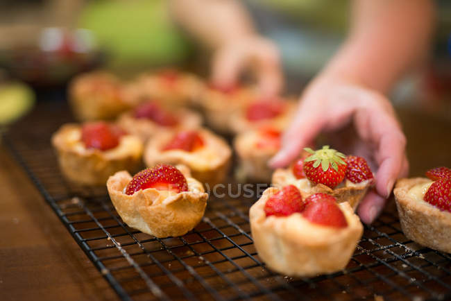 Close-up of girl hands holding fresh baked strawberry tarts — Stock Photo