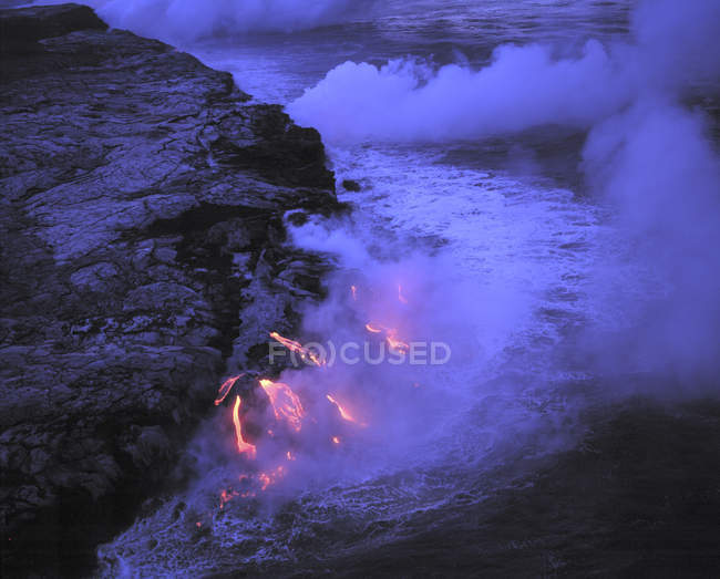 Лава, текущая в океан в Национальном парке Вулканов, Гавайи, США — стоковое фото