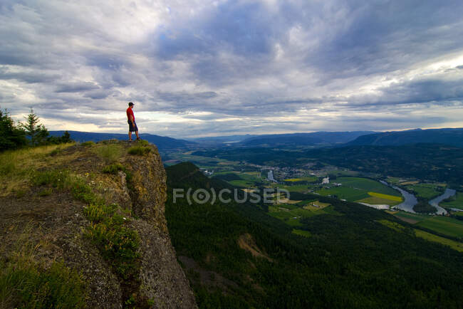 L'escursionista si gode la vista dopo un'escursione impegnativa ma gratificante in cima alle scogliere di Enderby, che domina Enderby, nella regione Okanagan / Shuswap della Columbia Britannica, Canada — Foto stock