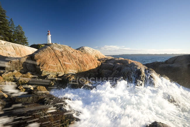 Wellen, die auf Felsen am Point atkinson Leuchtturm in West Vancouver, Britisch Columbia, Kanada — Stockfoto