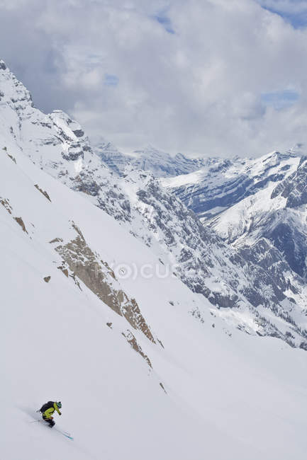 Esquiador de backcountry femenino esquiando en polvo escarpado, Icefall Lodge, Columbia Británica, Canadá - foto de stock