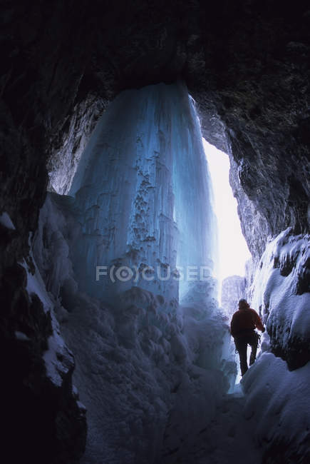 Scalatore di ghiaccio che fa strada nella grotta di Candlestick Maker, Ghost River, Rocky Mountains, Alberta, Canada — Foto stock