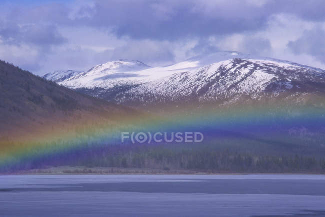 Rainbow over water of Surprise Lake, Atlin, Columbia Británica, Canadá - foto de stock