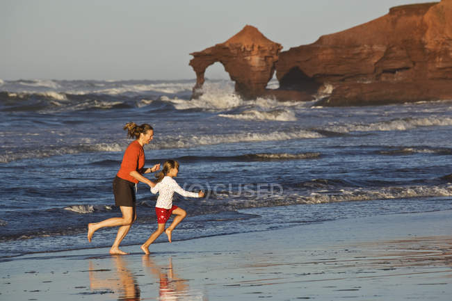 Mulher com filha correndo na praia em Profitts Point perto de Darnley, Prince Edward Island, Canadá . — Fotografia de Stock