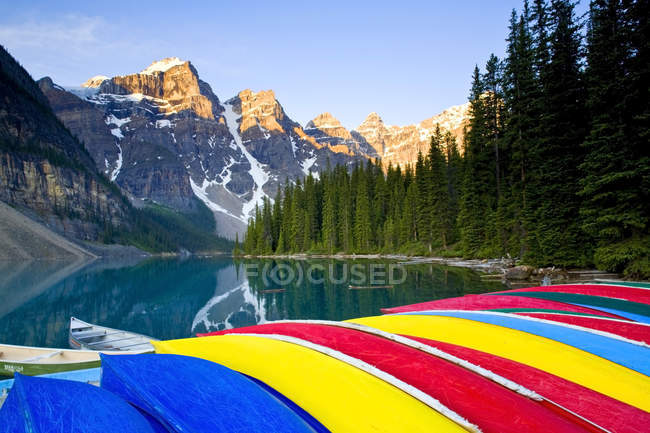 Canoas coloridas apiladas en el lago Moraine, Parque Nacional Banff, Alberta, Canadá - foto de stock