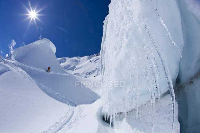 Backcountry skier touring up crevassed glacier at Icefall Lodge, Golden, British Columbia, Canadá - foto de stock
