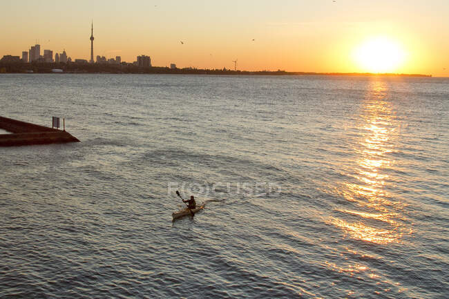 Jeune homme pagayant en kayak sur le lac Ontario à l'entrée de la rivière Humber, Toronto, Ontario, Canada. — Photo de stock