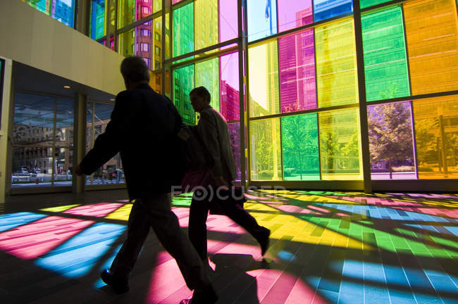 Empresários em silhueta por paredes de vidro coloridas do centro de convenções de Montreal, Montreal, Quebec, Canadá
. — Fotografia de Stock