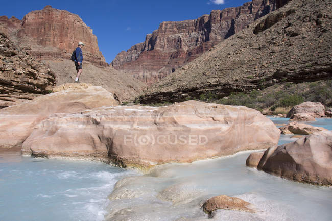 Caminhante no Little Colorado River colorido por carbonato de cálcio e sulfato de cobre em Grand Canyon, Arizona, Estados Unidos — Fotografia de Stock