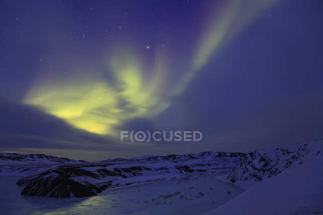 Aurora borealis au-dessus d'un lac gelé le long de la route Dempster, Territoires du Nord-Ouest, Canada . — Photo de stock