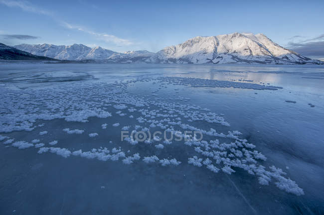 Cristalli di ghiaccio sulla superficie ghiacciata del lago Kluane con la montagna delle pecore nel parco nazionale di Kluane, Yukon, Canada . — Foto stock