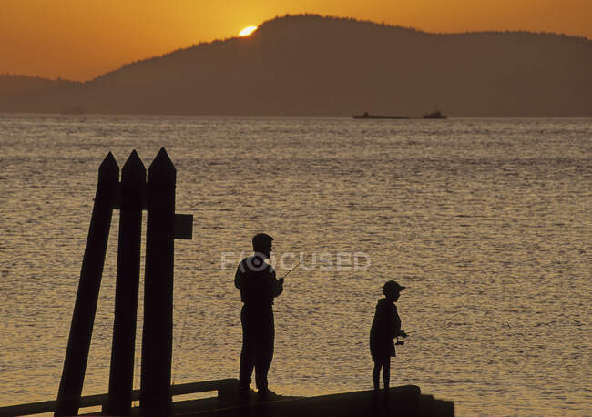Siluetas de personas pescando al atardecer, Islas San Juan, WA - foto de stock