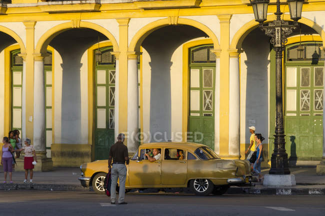 Scène de rue avec les habitants et vieille voiture à l'aube du soleil, La Havane, Cuba — Photo de stock