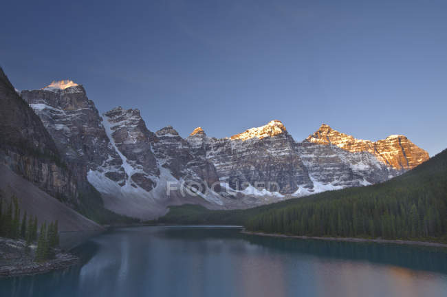 Alpenglühen auf felsigen Bergen mit Spiegelung im Moränensee, Tal der zehn Gipfel, Banff-Nationalpark, Alberta, Kanada. — Stockfoto