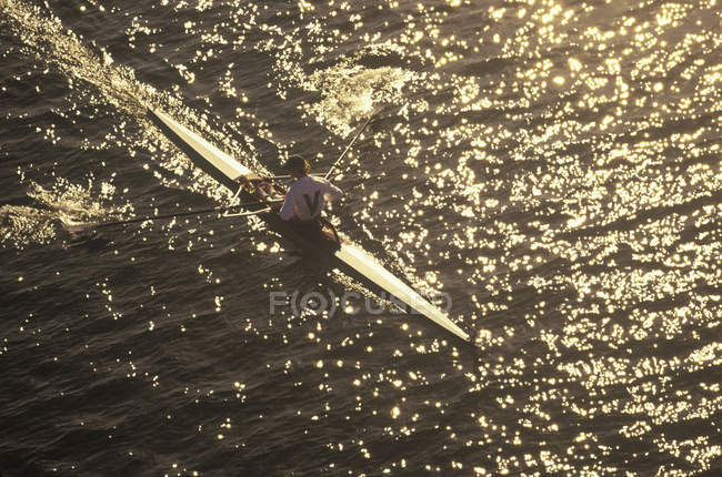 High angle view of unrecognizable person rowing boat on Elk Lake at sunset, Victoria, Vancouver Island, British Columbia, Canada. — Stock Photo