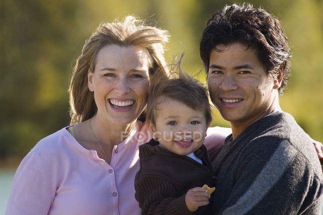 Pai, mãe e filho rindo e olhando para a câmera em Green Lake, Whistler, Canadá — Fotografia de Stock