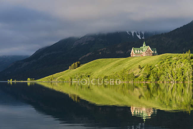 Prince of Wales Hotel refletindo na água do Parque Nacional dos Lagos de Waterton, Alberta, Canadá — Fotografia de Stock