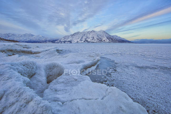 Lago parcialmente coberto de gelo e montanha de ovelhas em Kluane National Park, Yukon, Canadá . — Fotografia de Stock