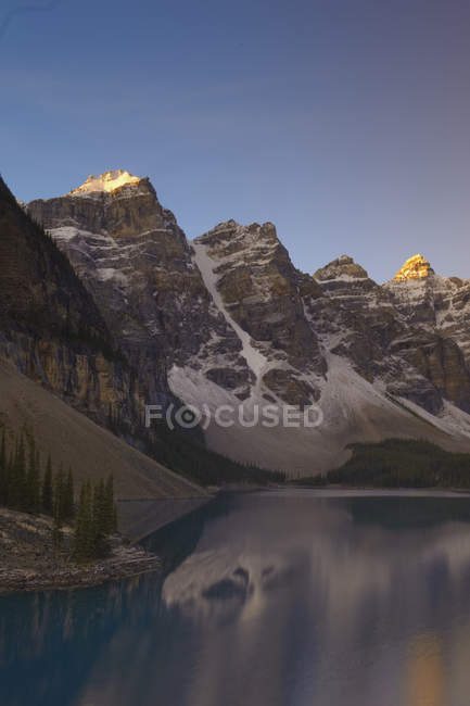 Alpenglow on Rocky mountains with reflection in Moraine Lake, Valley of Ten Peaks, Banff National Park, Alberta, Canadá . - foto de stock