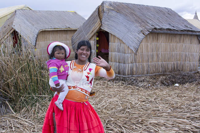 Local woman with child at floating reed island of Uros, Lake Titicaca, Peru — Stock Photo