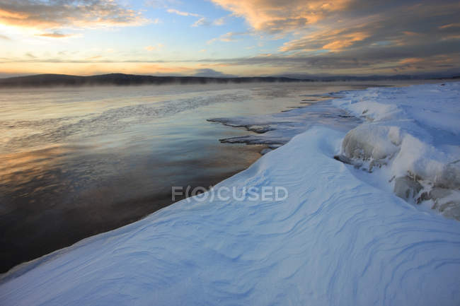 Coucher de soleil sur la rive glacée du lac Teslin, Teslin, Yukon . — Photo de stock