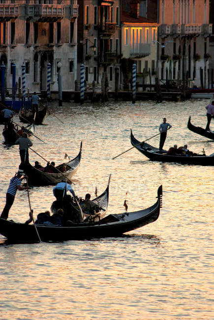 Góndolas llevando turistas por el Gran Canal en Venecia, Italia - foto de stock