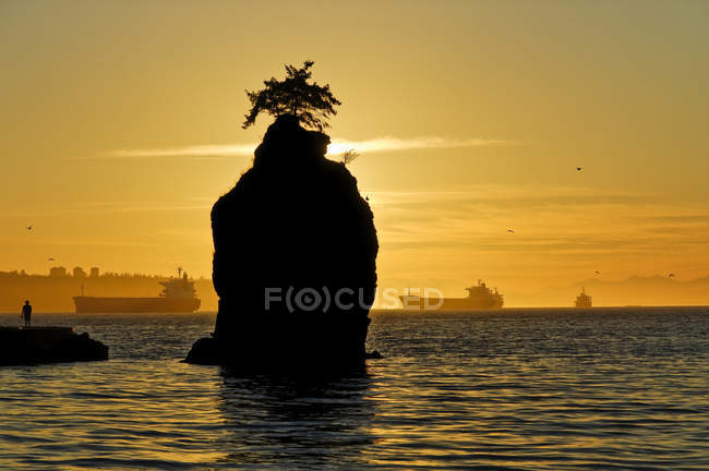 Siwash Rock and Stanley Park seawall with ships at sunset, Vancouver, Britsih Columbia, Canada — Stock Photo