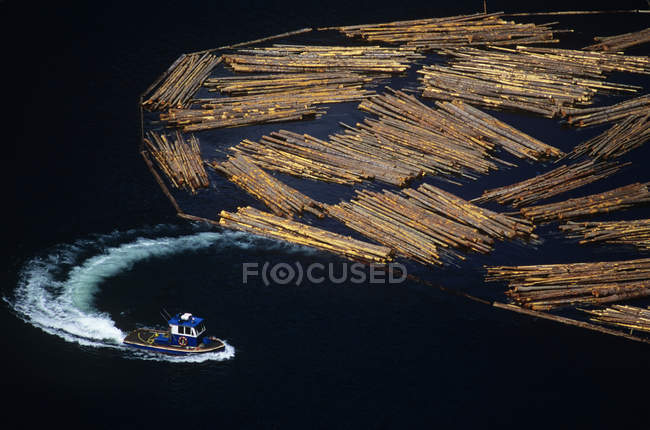 Log boom and vessel on water in Slocan Lake, West Kootenays, British Columbia, Canada. — Stock Photo