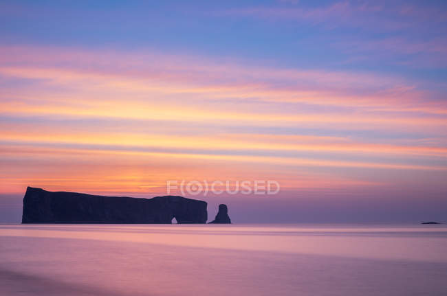 Perce Rock sheer rock formation in water before sunrise, Gaspesie, Quebec, Canada. — Stock Photo