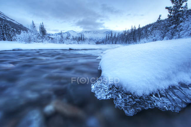 Alba sopra le rocce di ghiaccio coperto a Wheaton River vicino a Whitehorse, Yukon, Canada. — Foto stock