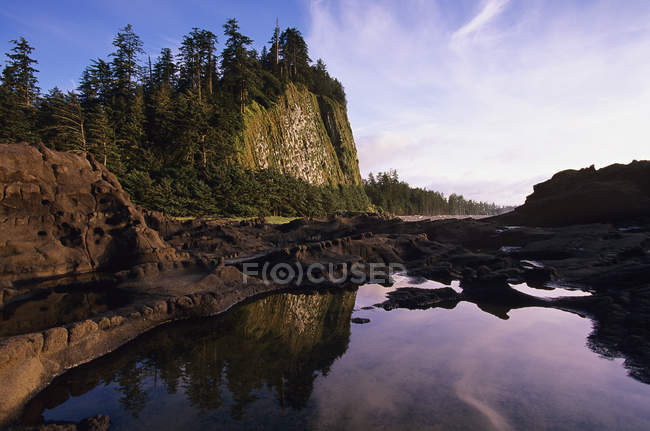 Scène tranquille du littoral rocheux de Haida Gwaii avec Tow Hill sur l'île Graham au crépuscule, Colombie-Britannique, Canada . — Photo de stock
