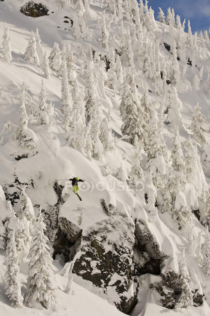 Hombre freeskier aireando acantilado en Revelstoke Backcountry Resort, Canadá - foto de stock