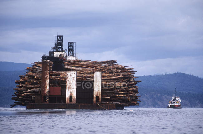 Barcaça de toras com carga de toras e barco, British Columbia, Canadá . — Fotografia de Stock